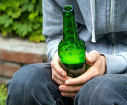 Bottle in hands representing anti-social behaviour