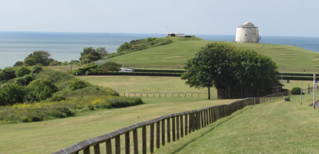 East Cliff open space with a Martello Tower and the sea in the distance.