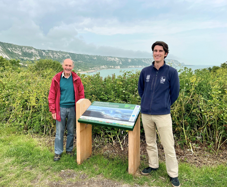 An image of Cllr Stephen Scoffham (right) and Greg Taylor standing next to an information board at East Cliff Folkestone