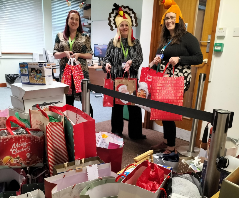 An image of three council staff members with the presents given to this year's Wish Upon A Star appeal