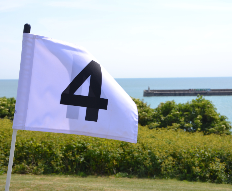 A golf flag with the number four written on it in front of Folkestone&#039;s Harbour Arm.
