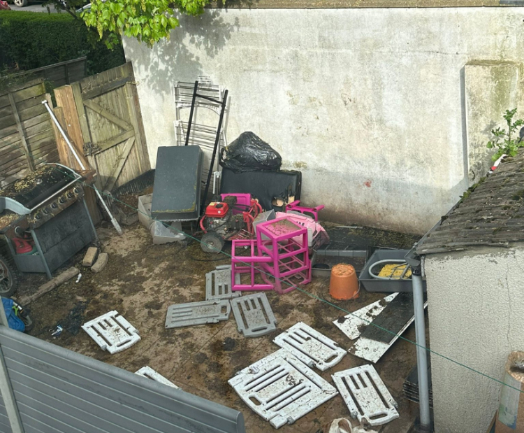 A photograph of a back garden with various waste