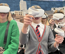 An adult and children wear white virtual reality headsets at an engagement event