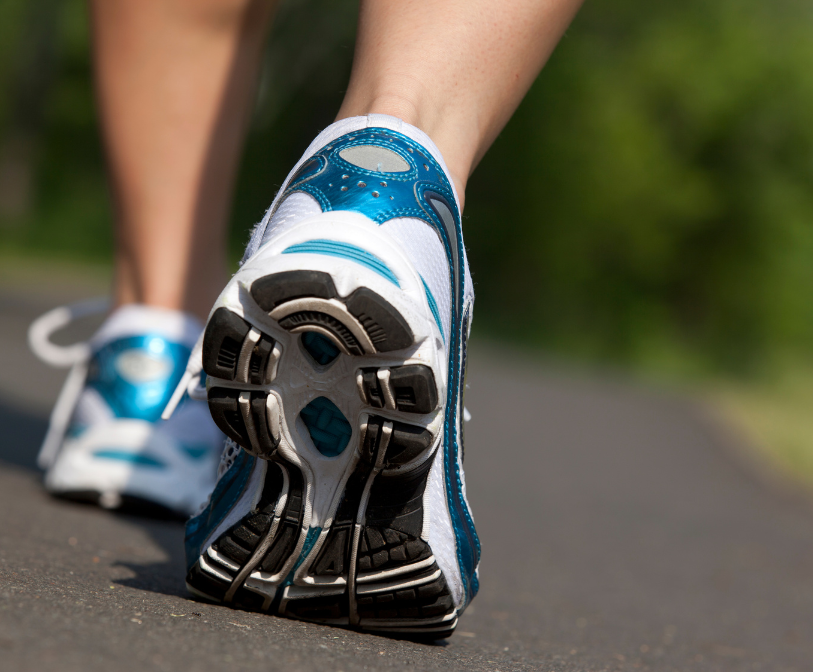 A close-up photo of a person walking along a pavement.