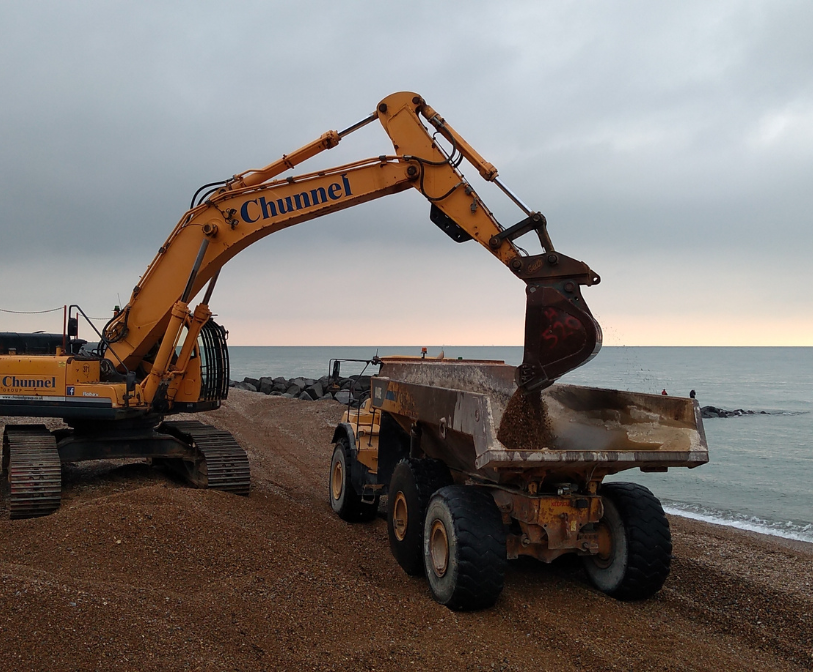 A photograph of machinery carrying out beach management work.