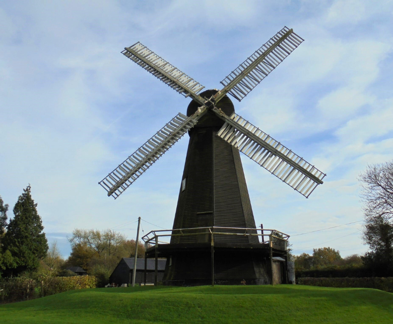An image of the Stelling Minnis windmill against a blue sky on green grass