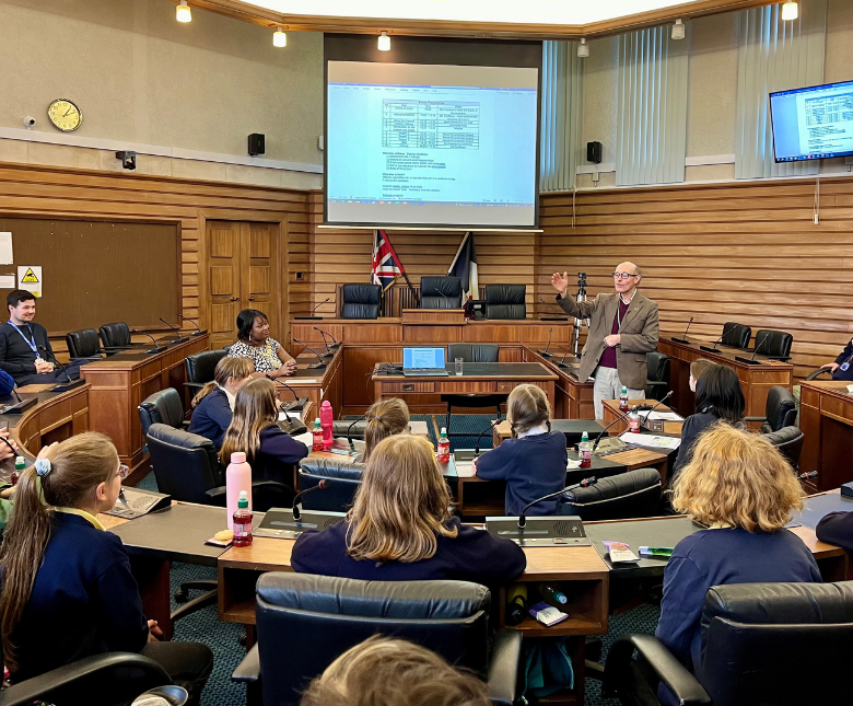 An image of young people from schools attending a session at the council chamber with councillors presenting their sustainable ideas