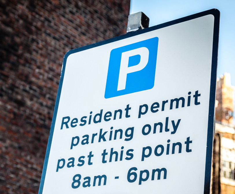 A photograph of road-side signage which reads: Resident permit parking only past this point (8am-6pm)