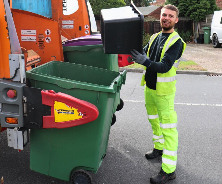 An image of a member of the waste crew disposing of a waste bin