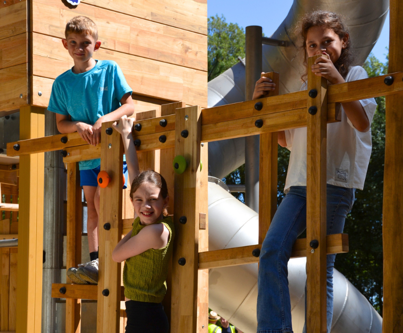An image of three children climbing on new play equipment at the Lower Leas Coastal Park in Folkestone.