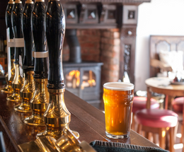 The bar of a pub with a pint of beer on the counter